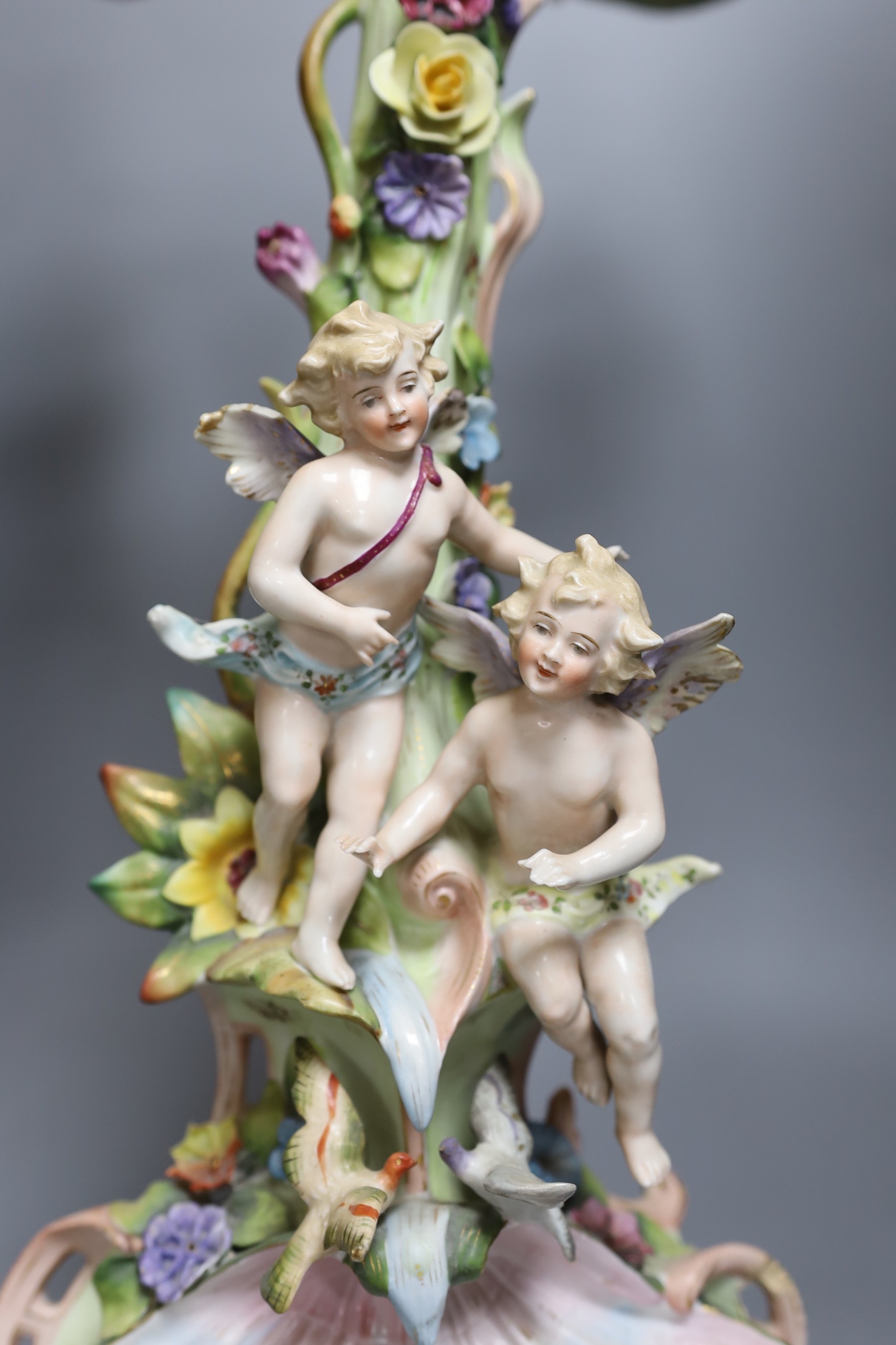 Two German floral encrusted candelabra, tallest 55cm